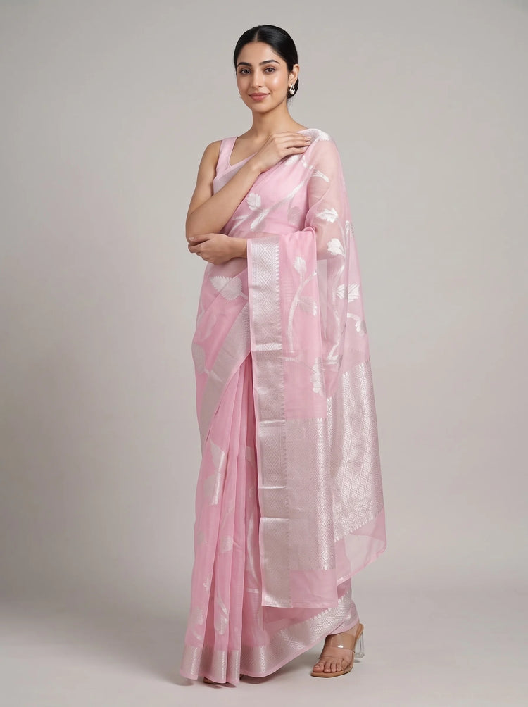 Front view of elegant pink cotton woven saree with the model’s right hand near her chest, highlighting the woven design and border