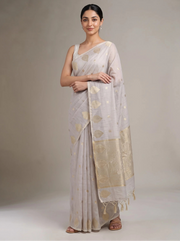 Front view of lilac purple cotton zari stripe saree with the model’s right hand near her chest, highlighting the golden zari stripes and border