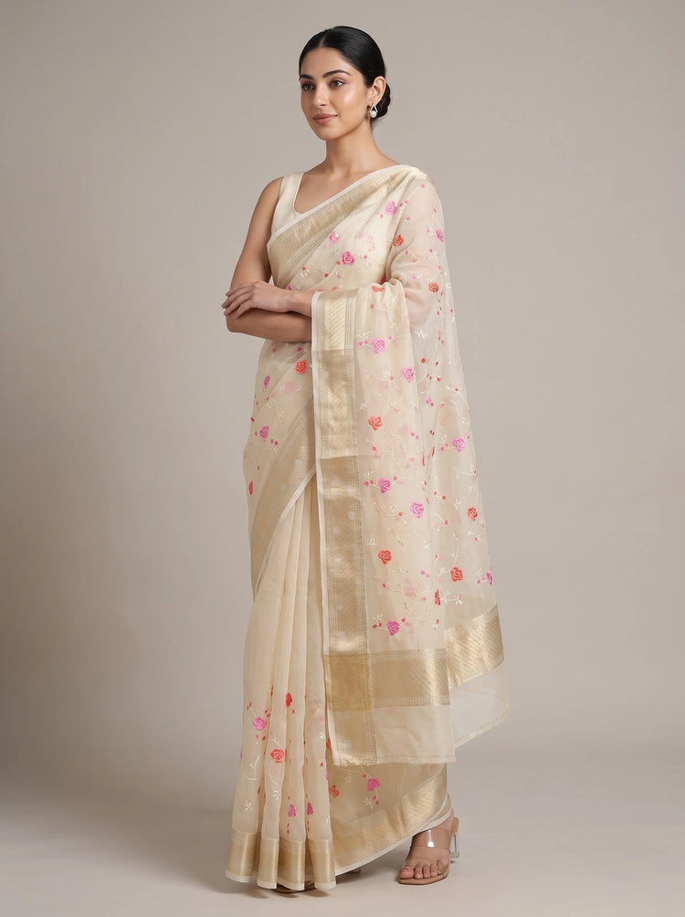 Front view of cream Munga Kota cotton Banarasi embroidered saree with the model’s right hand near her chest, highlighting the floral embroidery and Banarasi border