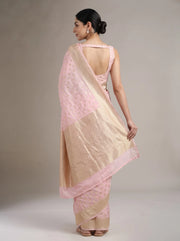 Back view of baby pink Chanderi cotton saree showing the blouse, graceful drape and detailed woven border