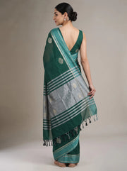 A woman modeling a green and silver striped cotton saree, shown from the back against a neutral beige studio background.