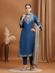 Woman wearing a blue embroidered outfit with a brown background