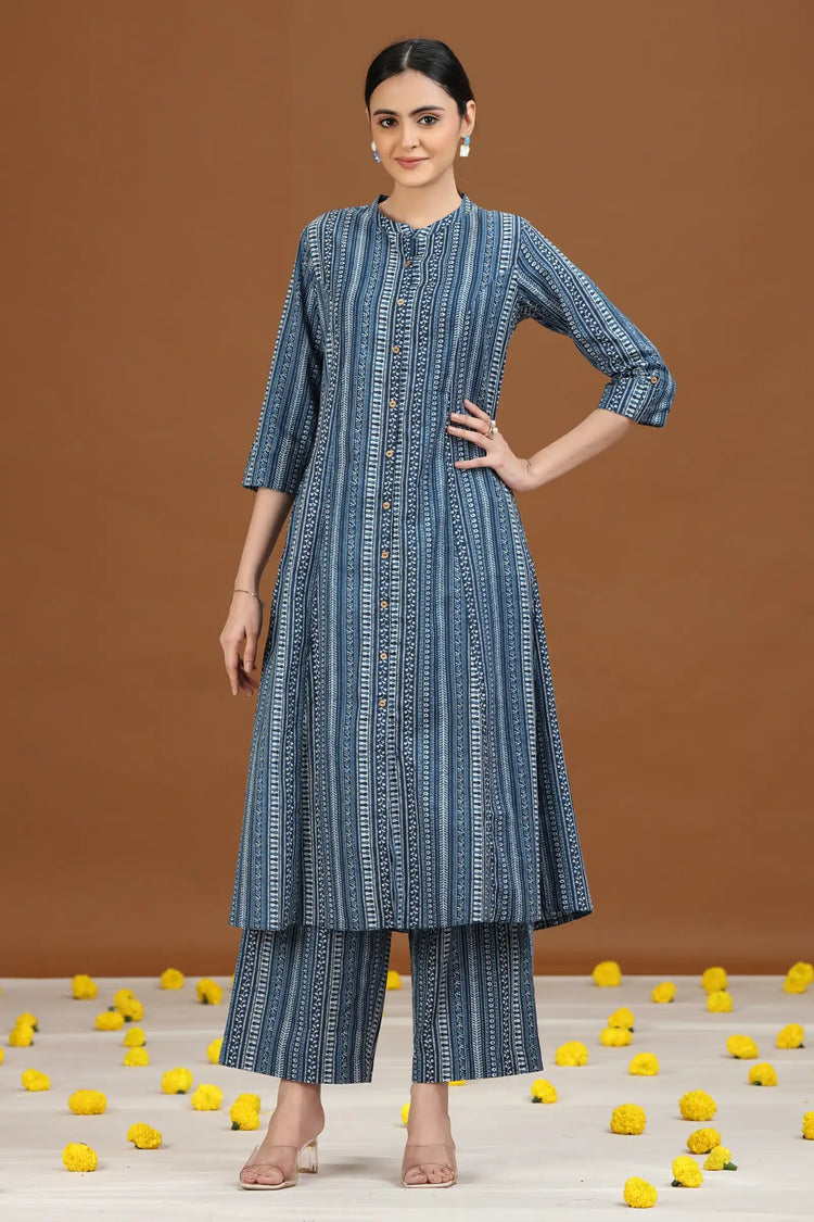Woman wearing a blue patterned kurta with pants on a brown background