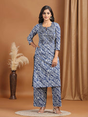 Woman wearing a blue patterned kurta with pants on a brown background