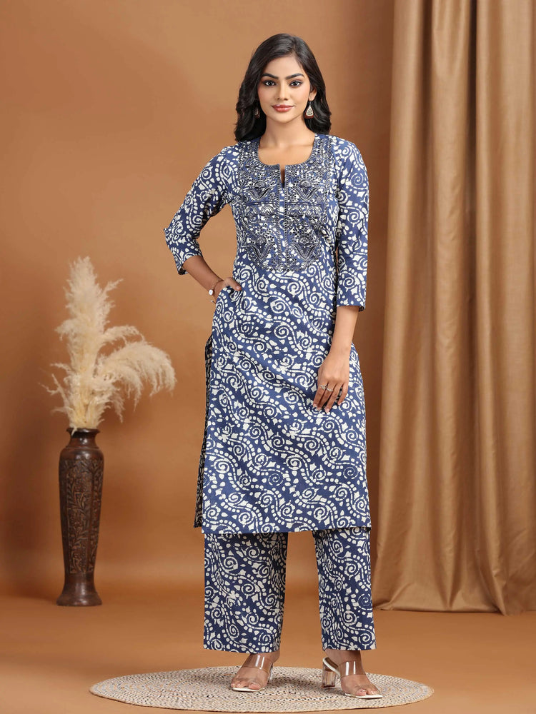 Woman wearing a blue patterned kurta with pants on a brown background