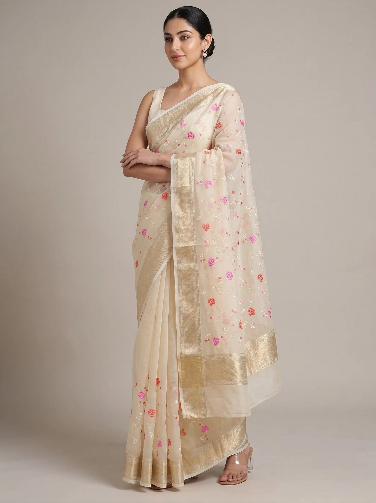 Front view of cream Munga Kota cotton Banarasi embroidered saree with the model’s right hand near her chest, highlighting the floral embroidery and Banarasi border