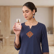 A hand holding a square glass perfume bottle labeled 'Cotton Culture GRACE' against a plain white background.