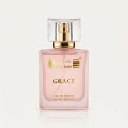 A bottle of Cotton Culture GRACE Eau de Parfum with a peach-colored glass body and a gold cap, surrounded by decorative natural ingredients including a pear, white flowers, coffee beans, and pink berries on a white background.